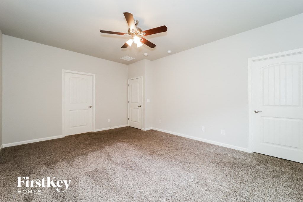 the master bedroom is spacious and clean with a ceiling fan