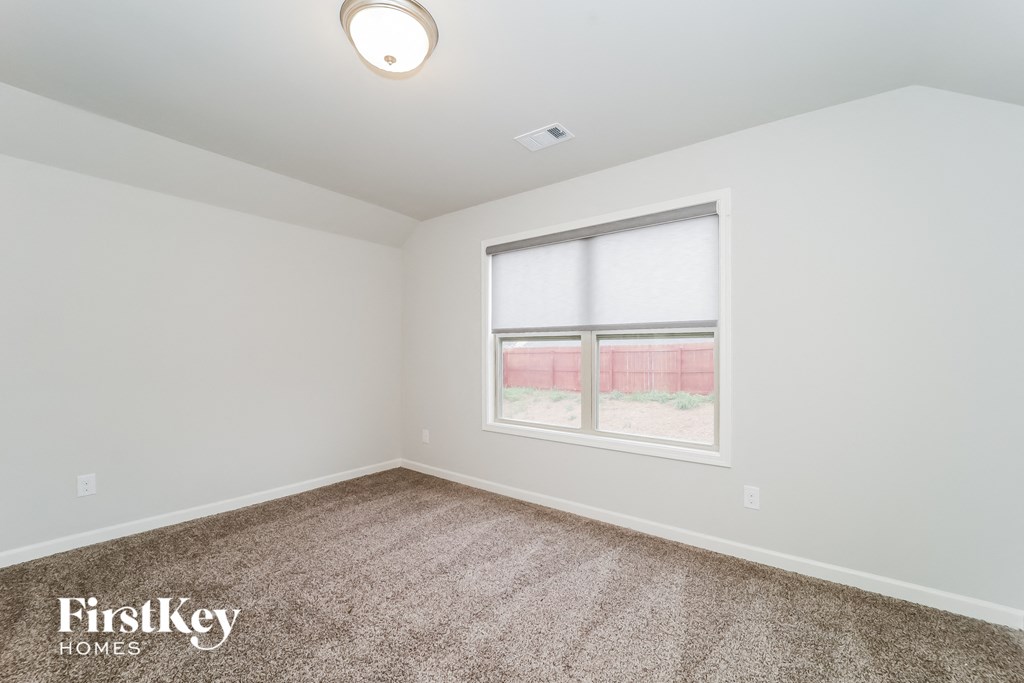 the living room of a home with carpet and a window