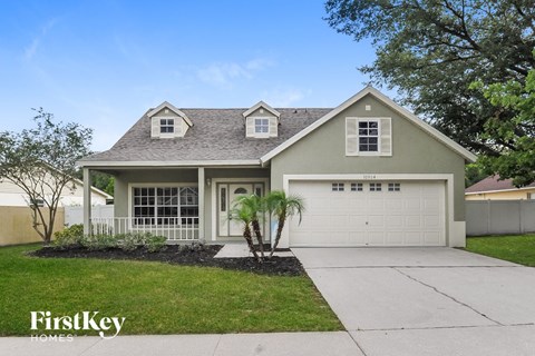A house with a garage and a driveway in front of it.