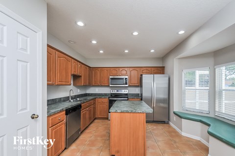 A kitchen with wooden cabinets and a refrigerator.