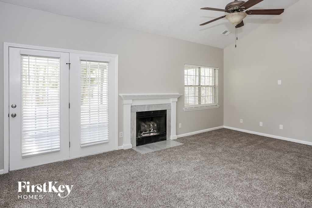a living room with a fireplace and a ceiling fan