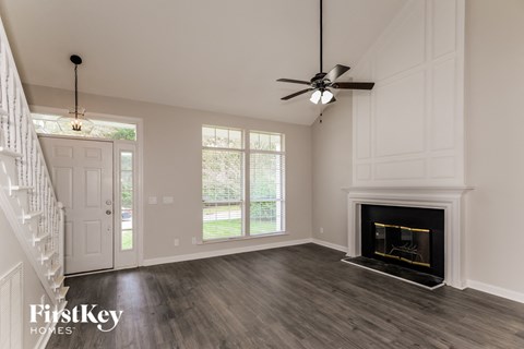a living room with a fireplace and a ceiling fan
