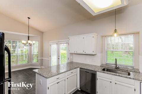 a kitchen with white cabinets and a granite counter top