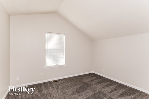 a bedroom with carpet and a window