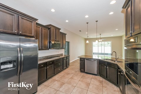 A kitchen with a refrigerator and a sink.