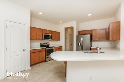 A kitchen with wooden cabinets and a white countertop.