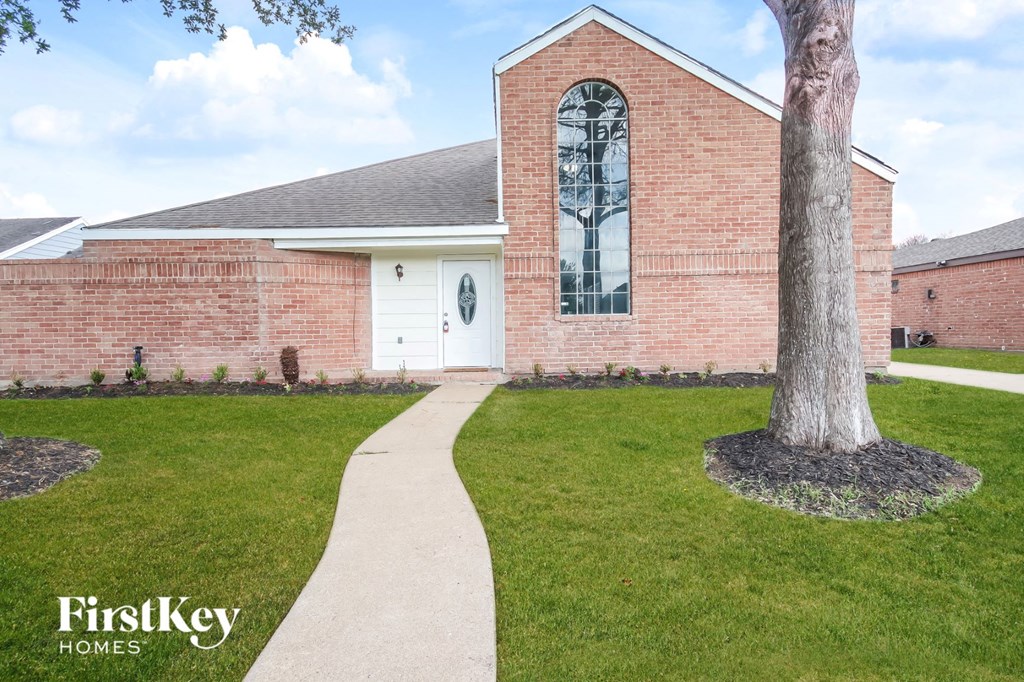 A brick house with a tree in front of it.