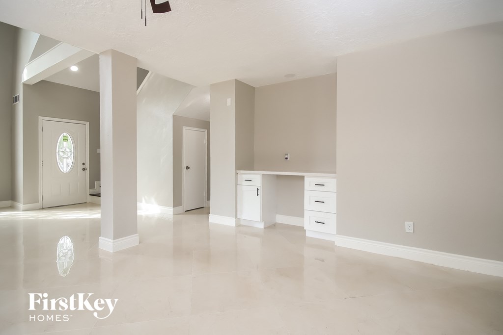 A spacious empty room with a desk and drawers.