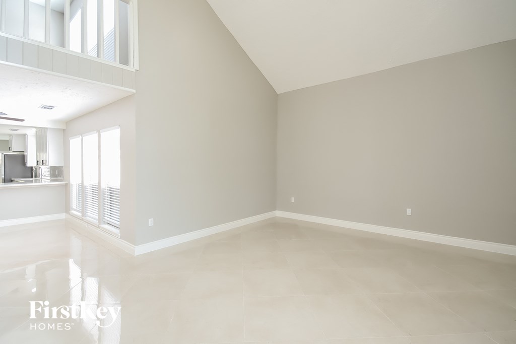 A spacious empty room with a FirstKey Homes logo.