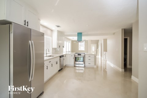 A modern kitchen with a refrigerator and a stove top oven.