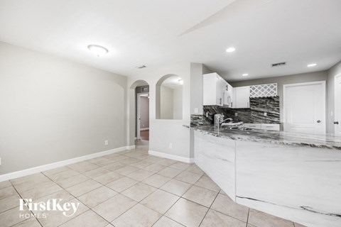 a large white kitchen with a marble counter top