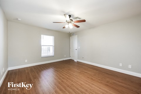 a living room with wood flooring and a ceiling fan