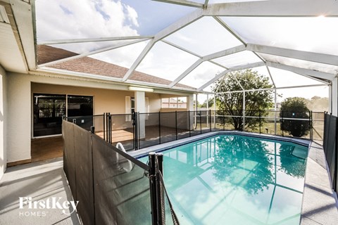 the pool is under a glass roof in the backyard of a house
