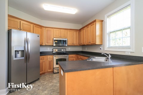A kitchen with wooden cabinets and a stainless steel refrigerator.