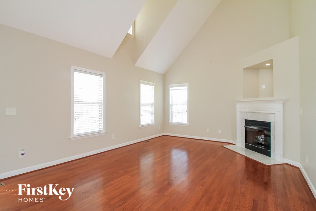 the living room with wood flooring and a fireplace