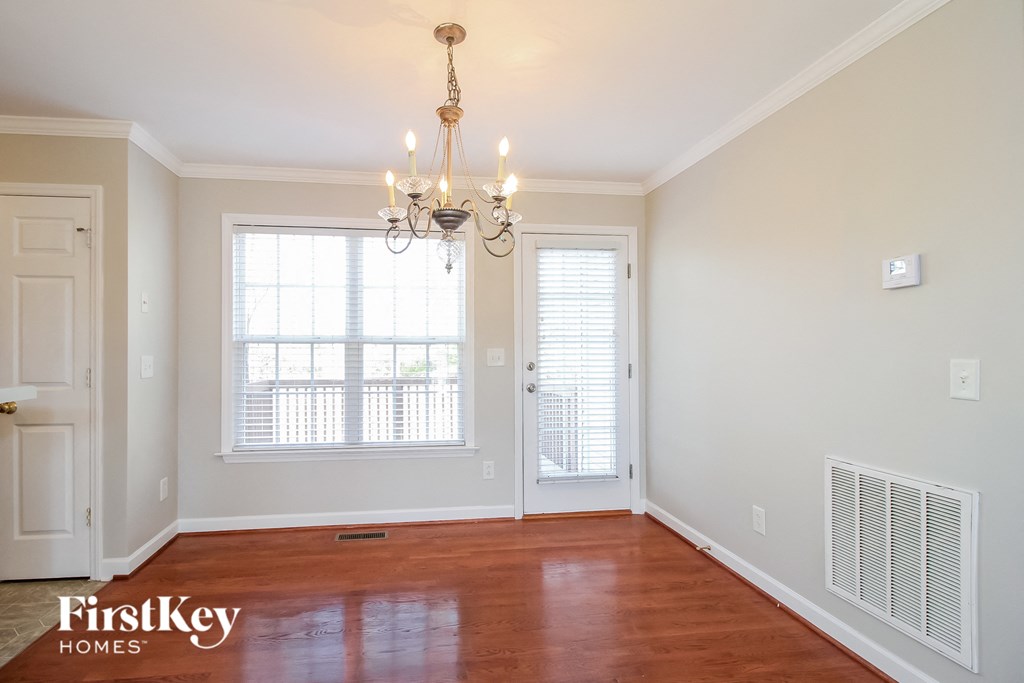 a living room with a large window and a chandelier