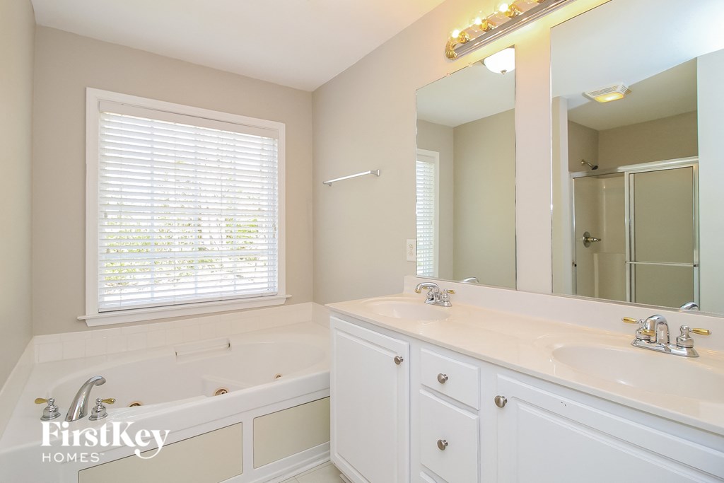 a bathroom with a tub and a sink and a mirror