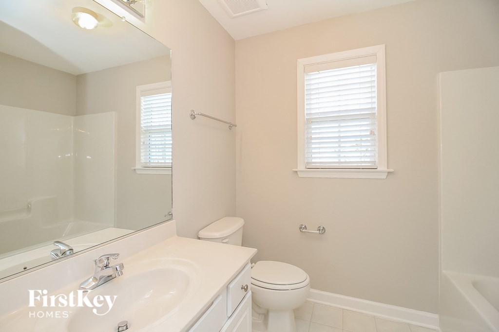 a bathroom with a sink toilet and a mirror