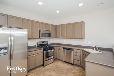A kitchen with brown cabinets and a stainless steel refrigerator.