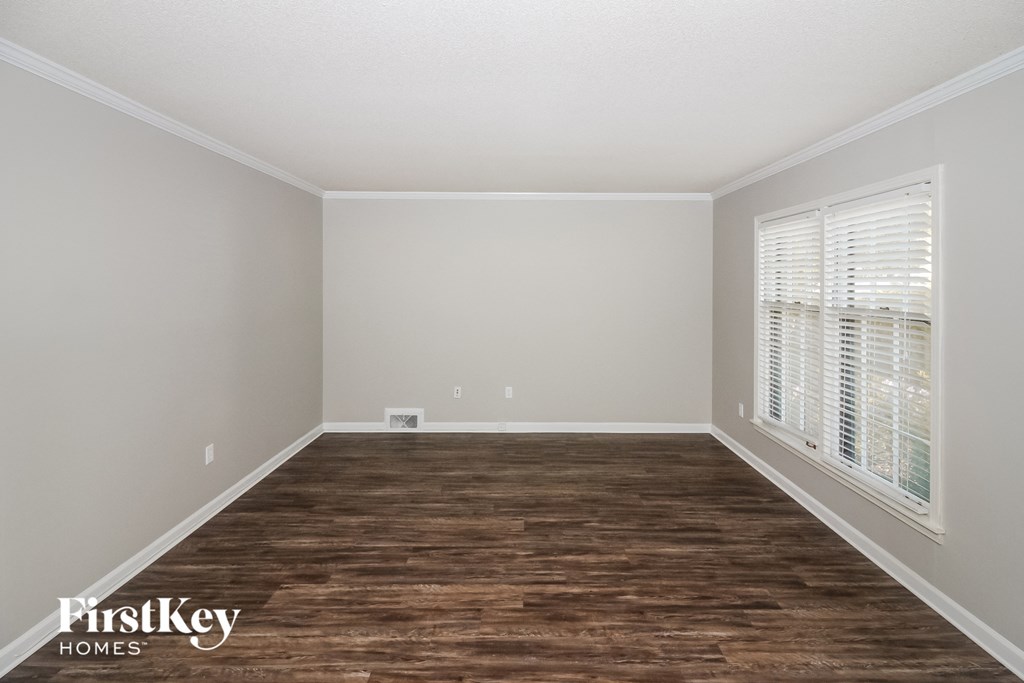 the living room of an empty house with wood floors and white walls