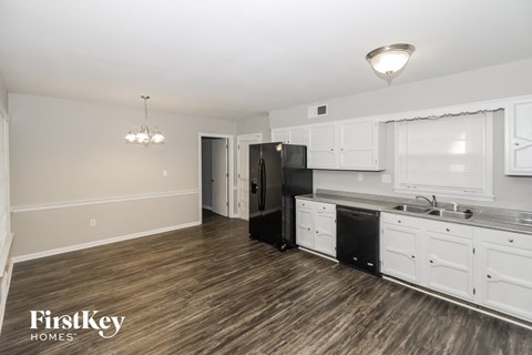 a kitchen with white cabinets and a black refrigerator