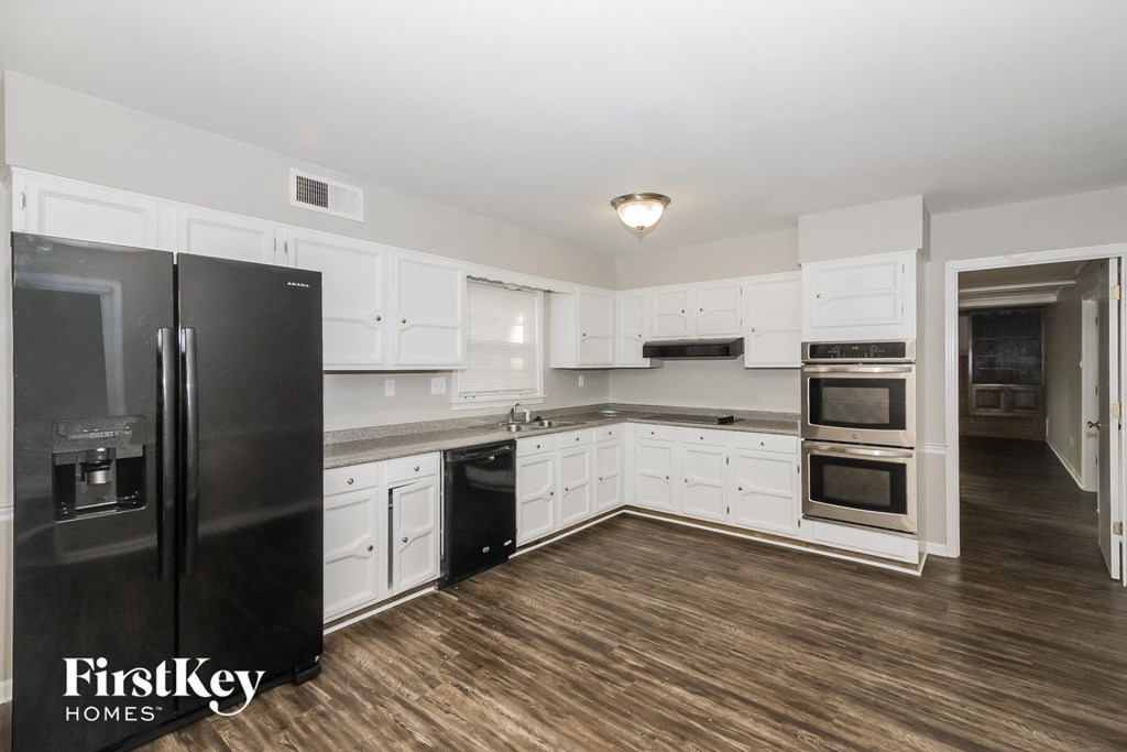 a kitchen with white cabinets and stainless steel appliances
