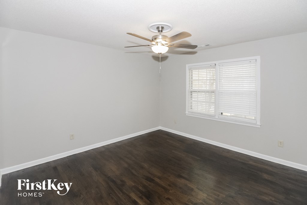 a bedroom with hardwood flooring and a ceiling fan
