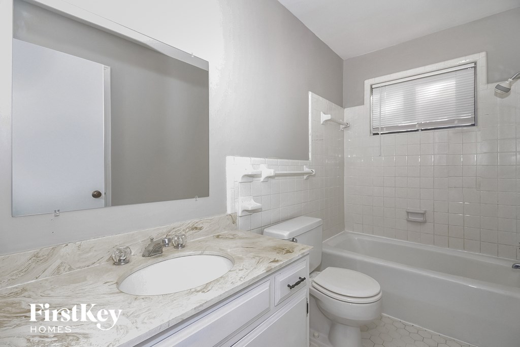 a white bathroom with a sink and a toilet and a tub