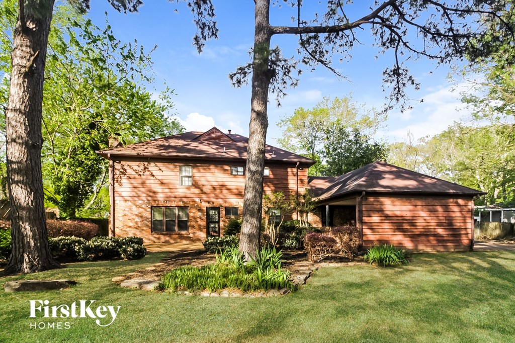 a small brick house with a yard and trees