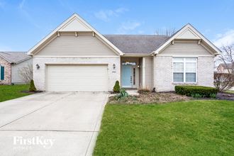 a white brick house with a blue door and a driveway