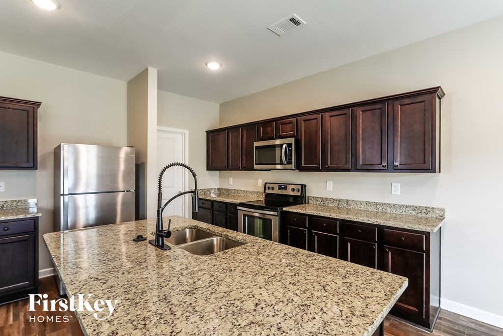 a kitchen with granite countertops and stainless steel appliances