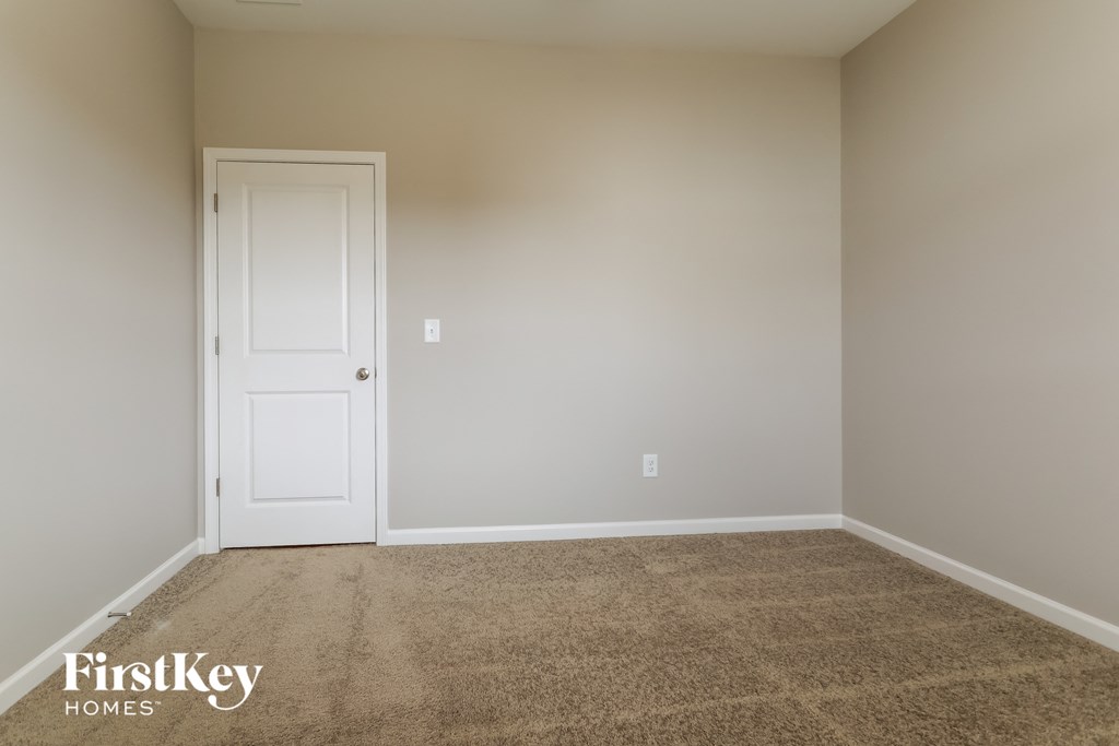 a empty room with carpet and a white door