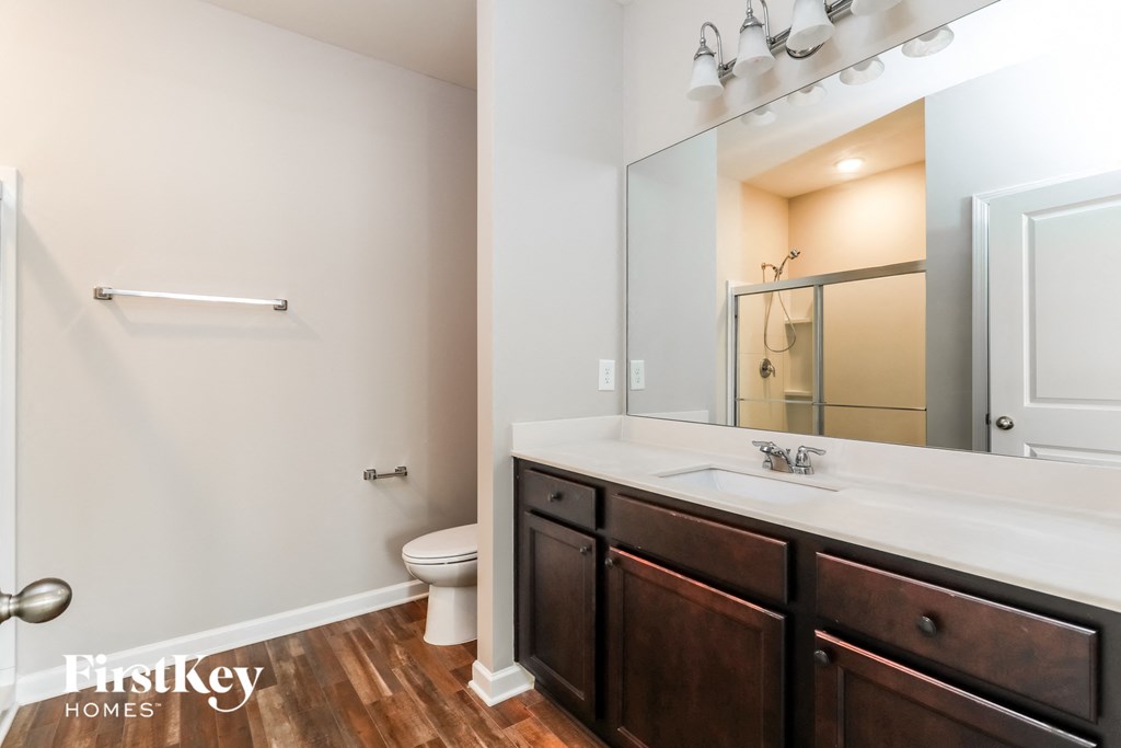 a bathroom with a large mirror and a sink and a toilet