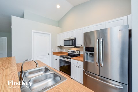 A kitchen with a stainless steel refrigerator and a wooden countertop.