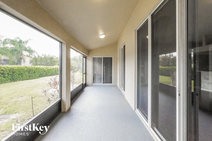 A long hallway with a view of a green lawn outside.