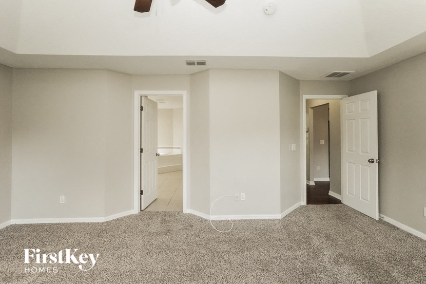 A spacious room with a carpeted floor and two doors.