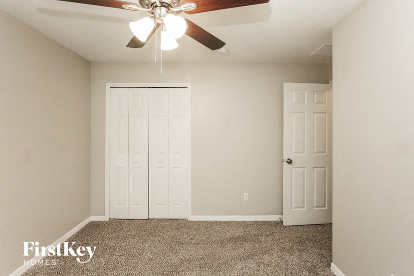 A room with a ceiling fan and two doors.