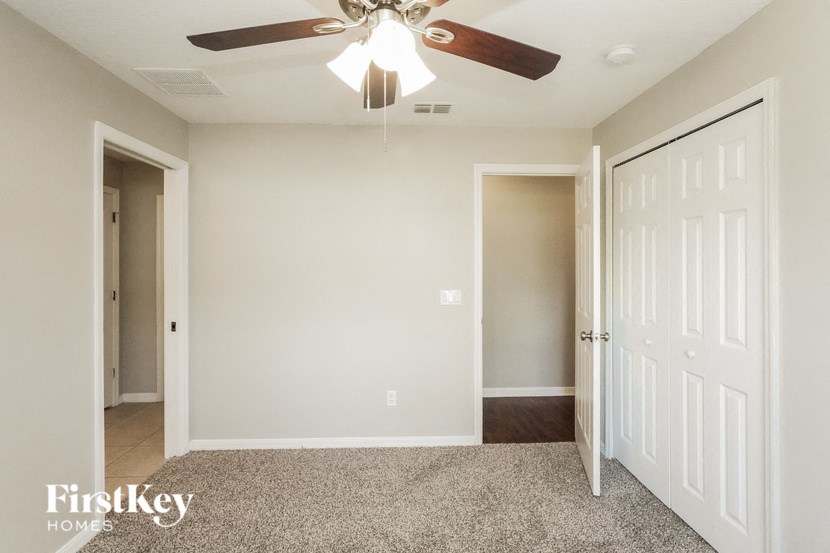 A room with a ceiling fan and a carpeted floor.