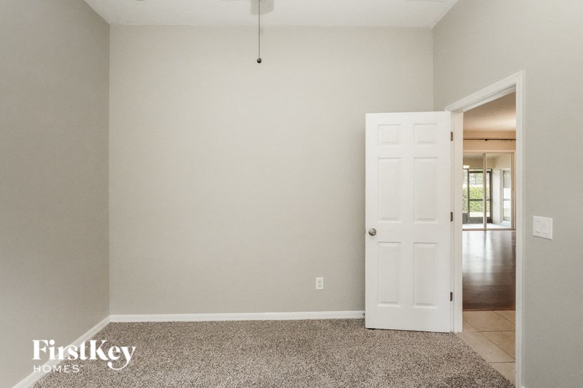 A room with a carpeted floor and a white door.