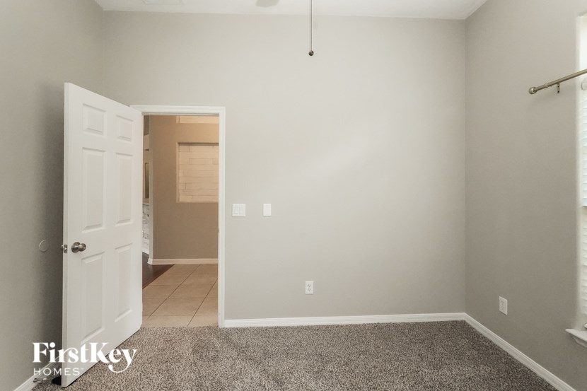 A room with a carpeted floor and a doorway leading to another room.