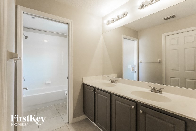 A bathroom with a white sink and a white tub.