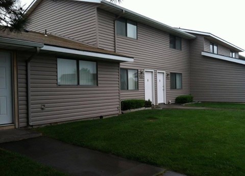 A house with a grey siding and a white door.