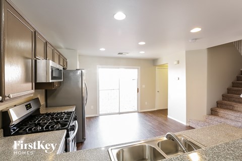 A kitchen with a stove top oven and a refrigerator.