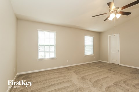 a living room with carpet and a ceiling fan