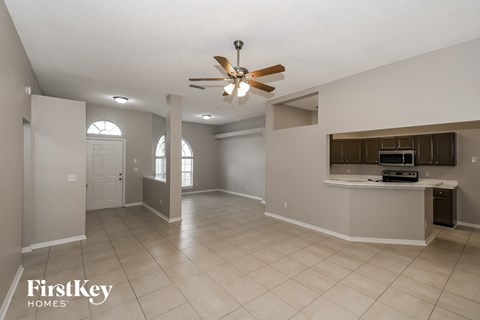 an empty kitchen and living room with a ceiling fan