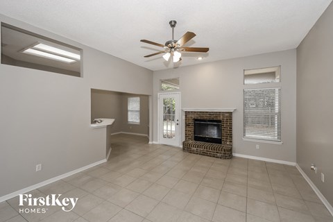 a living room with a fireplace and a ceiling fan
