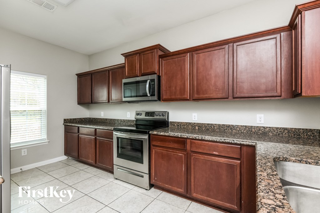 a kitchen with wood cabinets and stainless steel appliances and granite counter tops