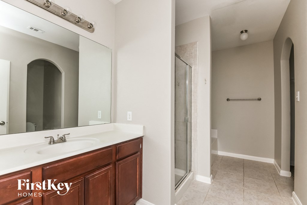 a bathroom with a large mirror and a sink and a shower