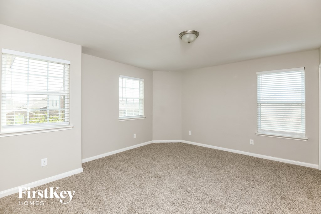 a bedroom with a carpeted floor and two windows