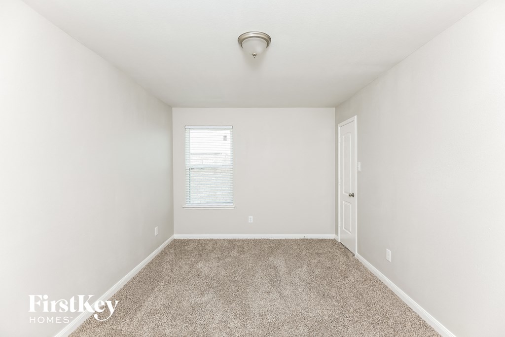 a spacious bedroom with carpet and a door to the bathroom